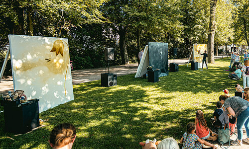 Maler malt auf drei Leinwänden im Freien.