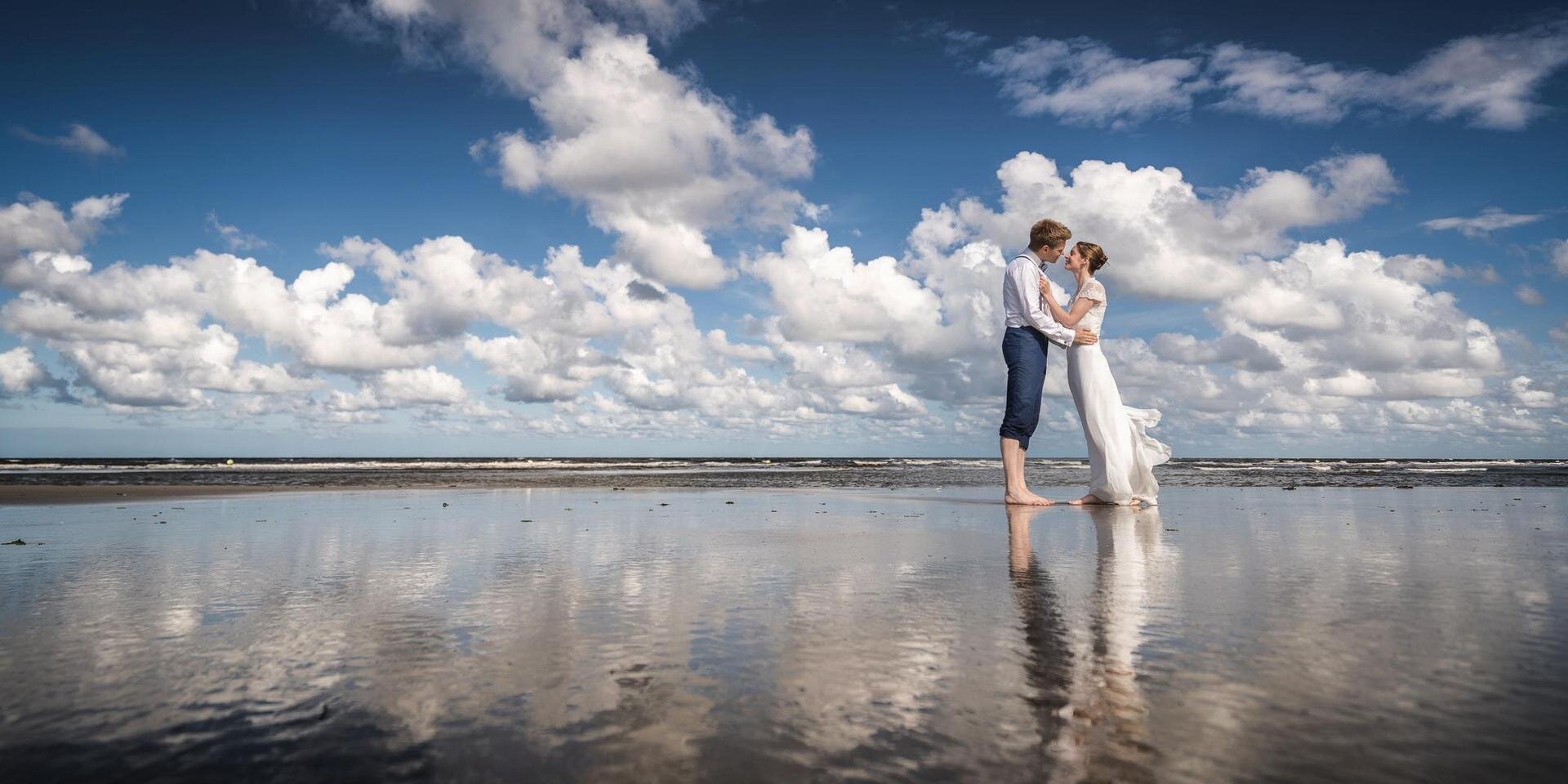 Hochzeitspaar küsst sich am Strand