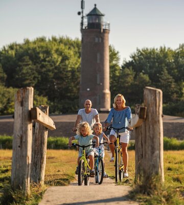 Familie beim Fahrradfahren vor dem Böhler Leuchtturm
