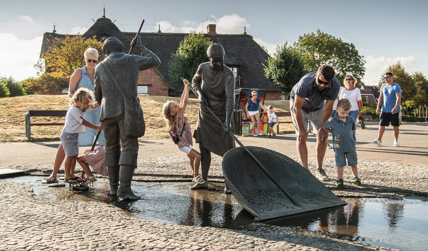 Familie bei den Figuren von Jan und Gret beim Marktplatz im Ortsteil Dorf