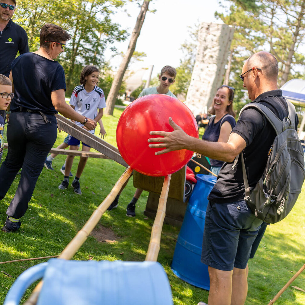Erwachsene und Kinder basteln gemeinsam an einer XXL-Maschine