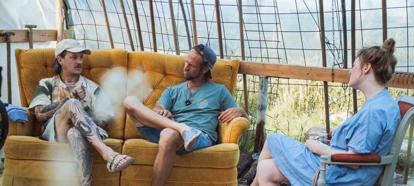 Three podcast hosts during a recording session in the greenhouse