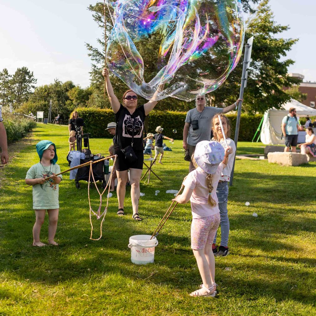 Familien stellen riesengroße Seifenblasen her