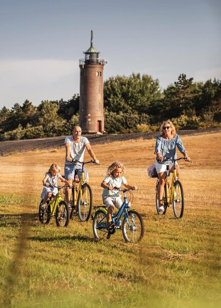 Familie beim Fahrradfahren vor dem Westerhever Leuchtturm