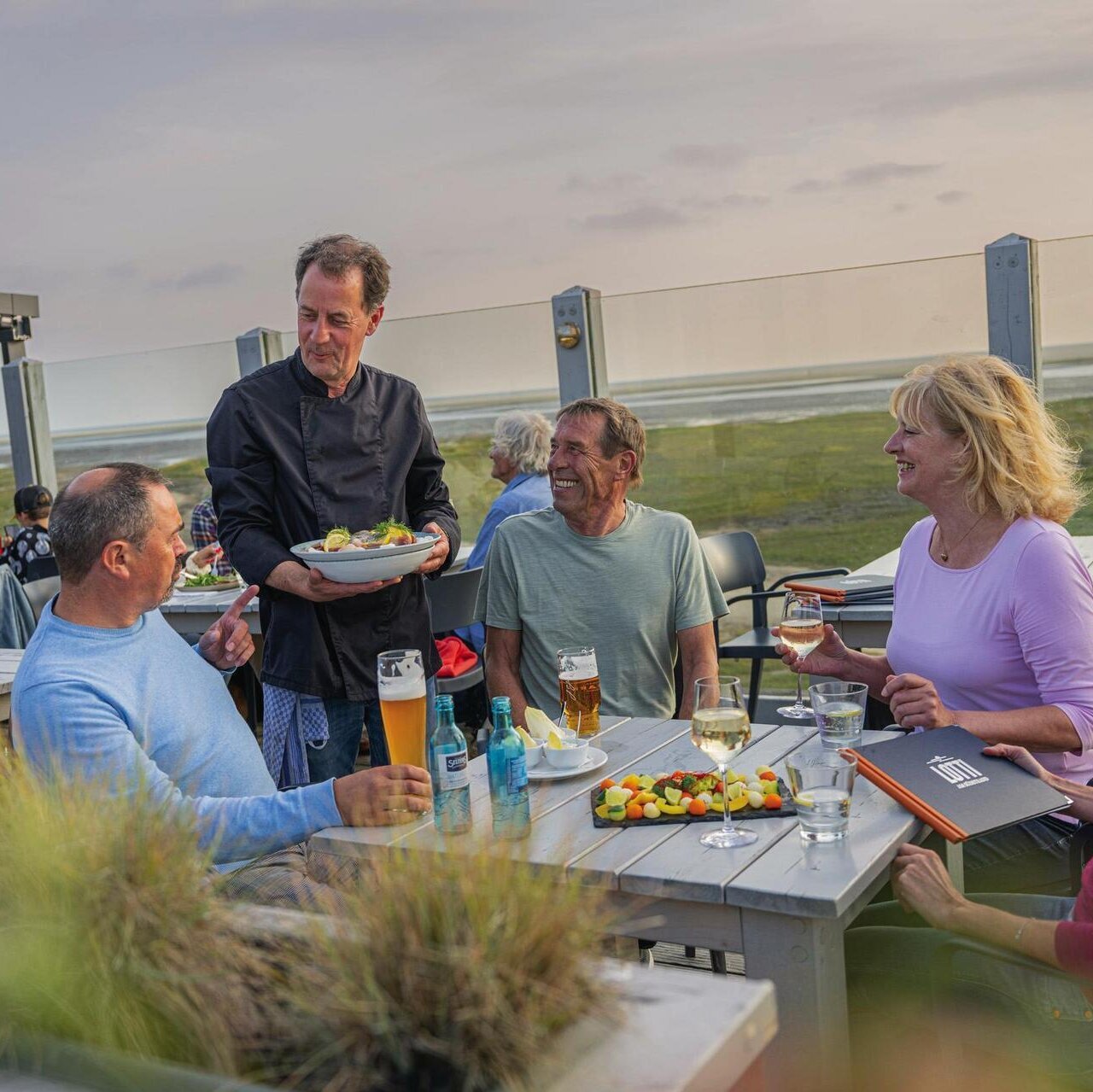Freunde auf der Dachterrasse des Pfahlbaurestaurants Lotti am Südstrand