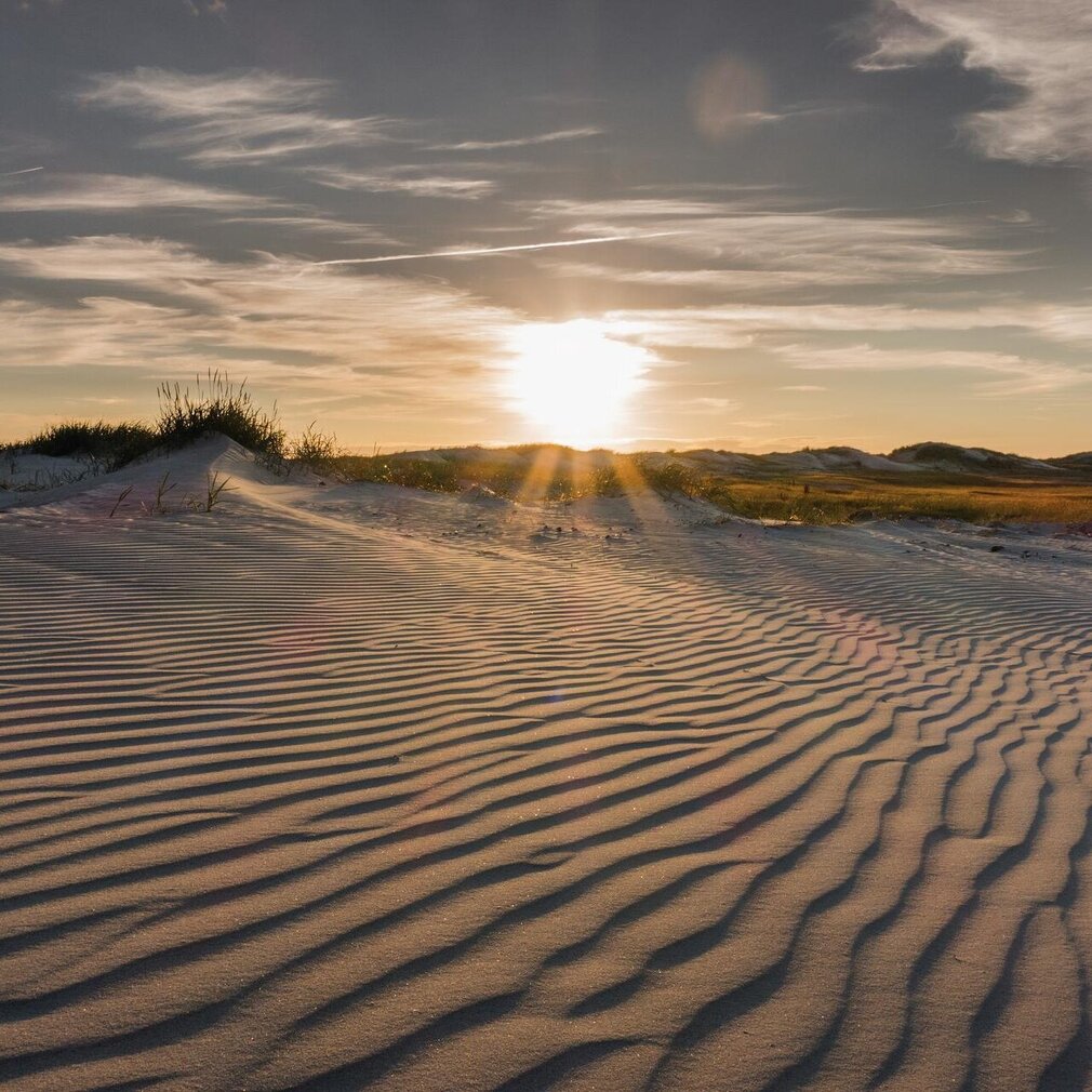 Dünen mit Sandstrukturen bei Sonnenuntergang
