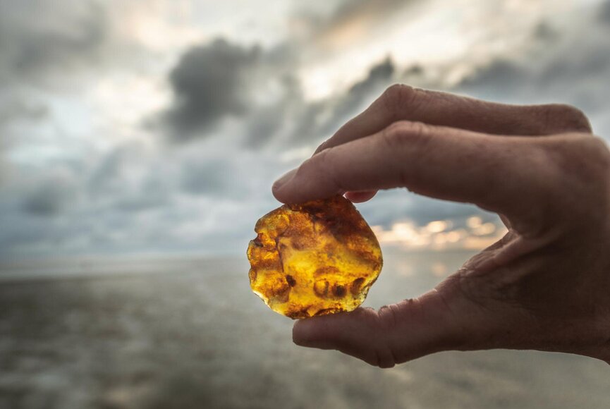 Hand hält Bernstein im Sonnenlicht