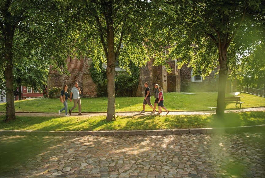 Menschen, die über den Marktplatz vor der Kirche spazieren