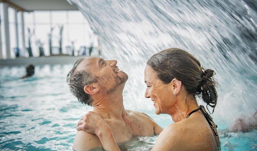 Mann und Frau unter der Powerdusche in der Dünen-Therme 