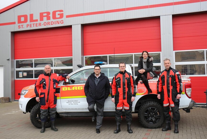 Team der DLRG in Überlebensanzügen vor einem Auto mit Katharina Schirmbeck und Jürgen Ritter