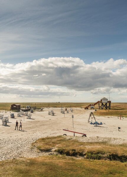 Südstrand, with stilt houses, a playground, and beach chairs