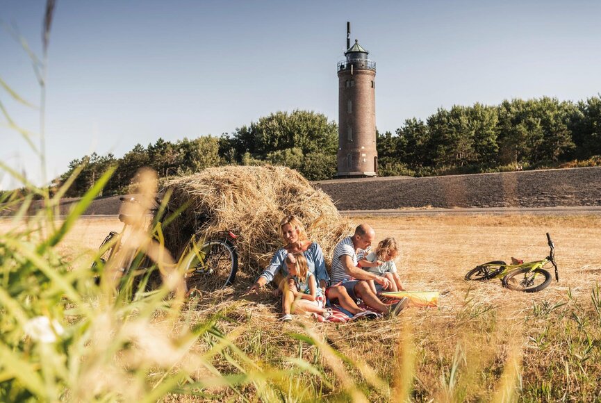 Familie mit Rädern auf der Wiese vor dem Böhler Leuchtturm