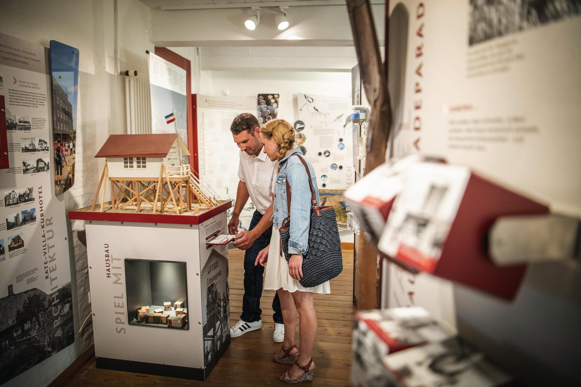 Paar beim Betrachten eines Pfahlbau-Modells im Museum Landschaft Eiderstedt