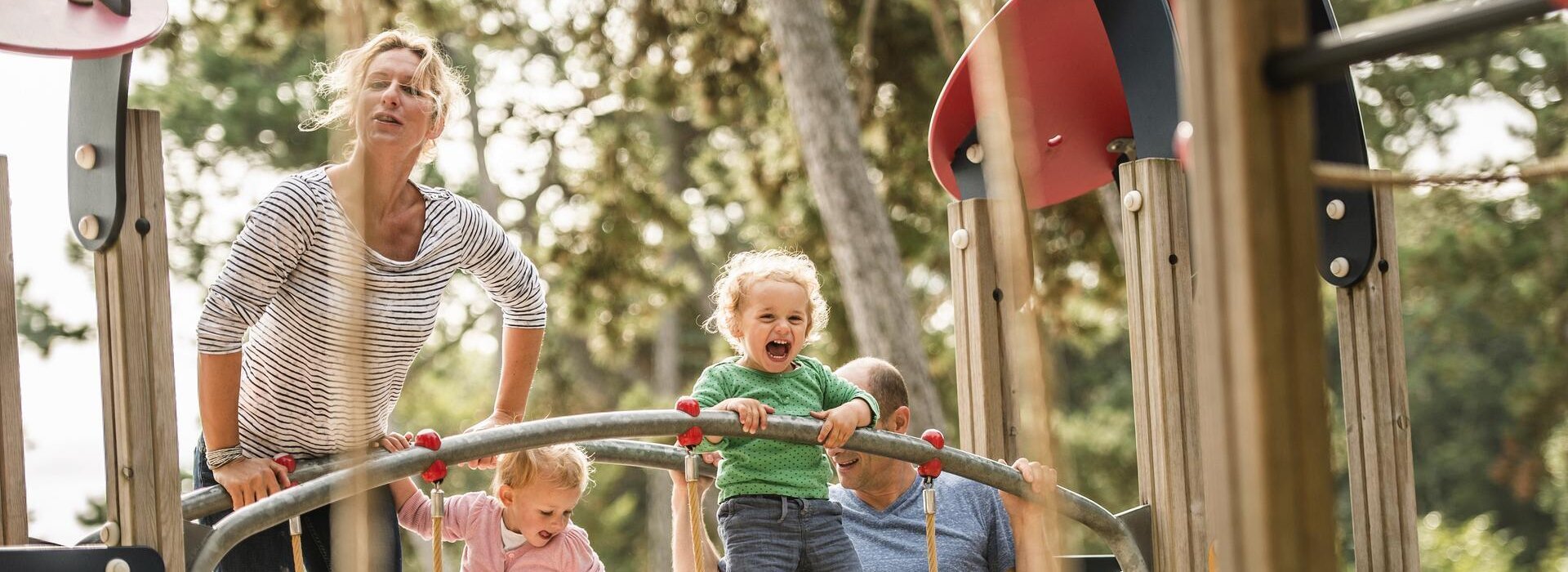 Familie auf einem Klettergerüst auf dem großen Outdoor-Spielplatz "Ponderosa"
