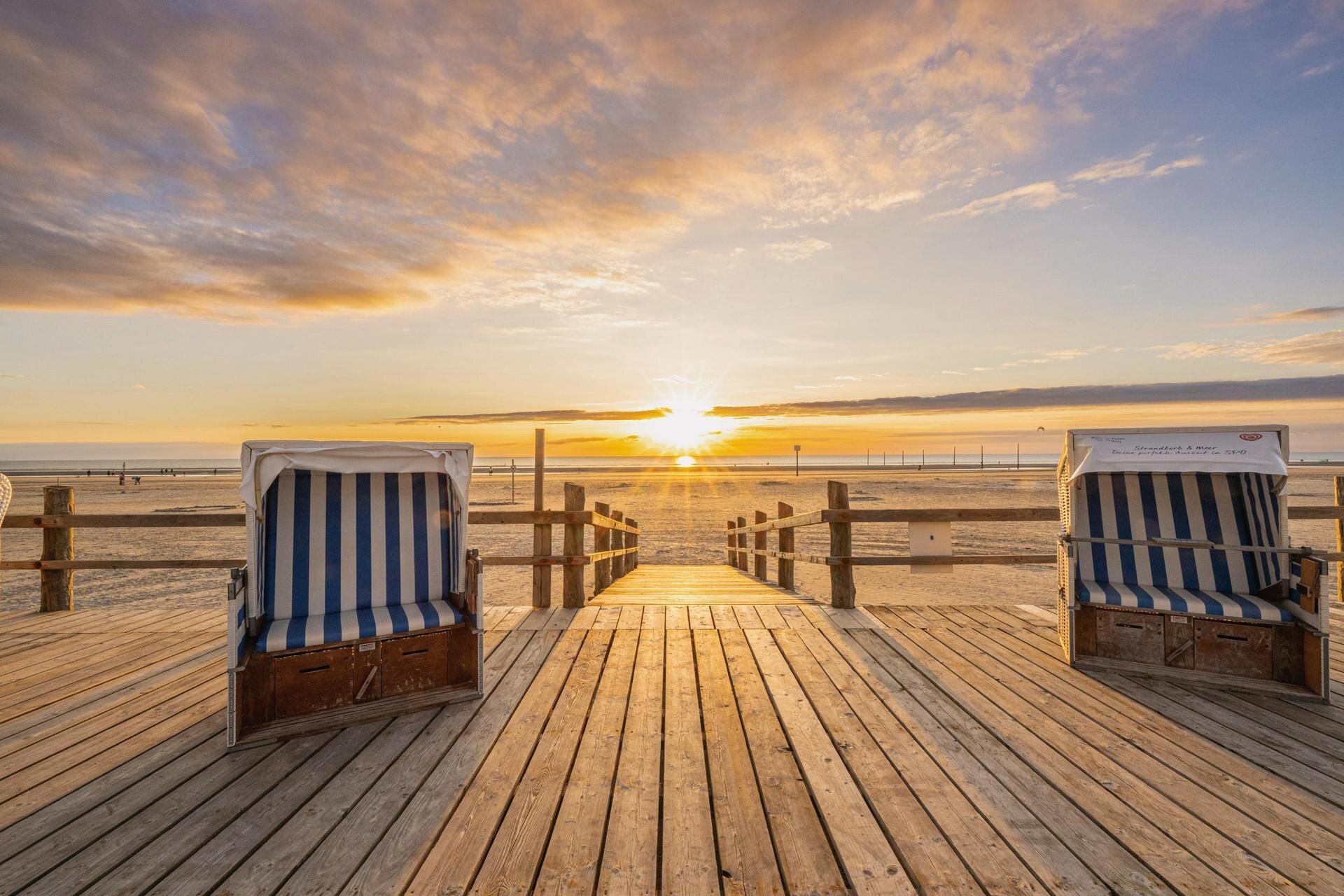 Strandkörbe auf dem Podest im Sonnenuntergang