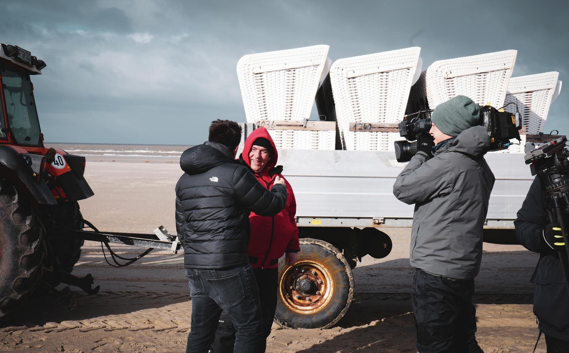 Interview eines Strandmitarbeiters vor einem Anhänger mit Strandkörben