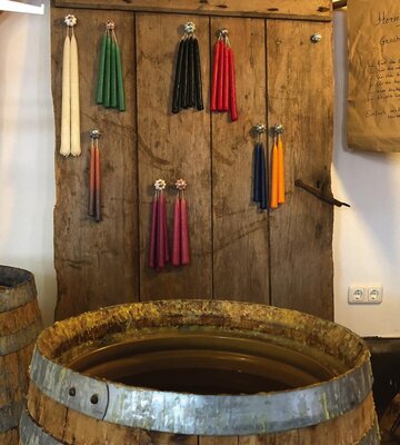 großes Fass mit frisch gezogenen Kerzen darüber