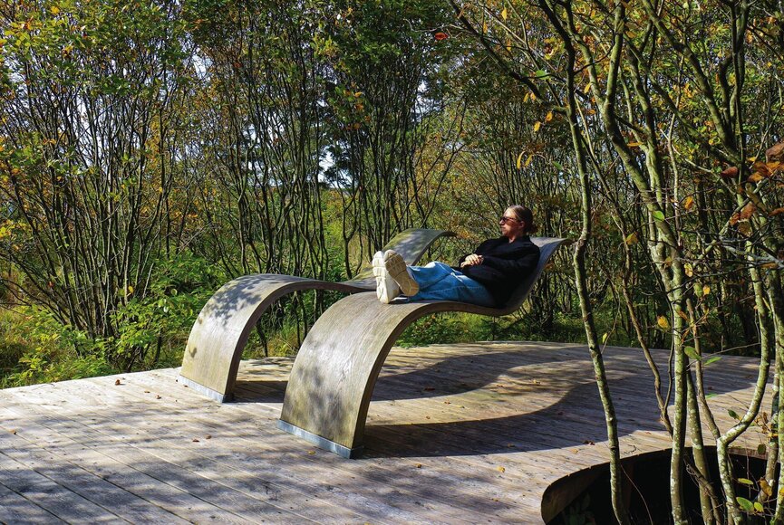 Frau auf schwebender Liege auf Naturpfad