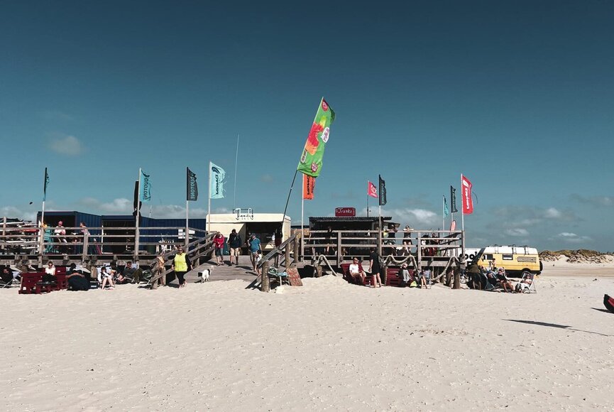 Surfschule am Strand mit Containern auf einem Pfahlbaupodest