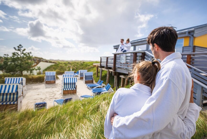 Paar blickt über den Dünengarten mit Strandkörben