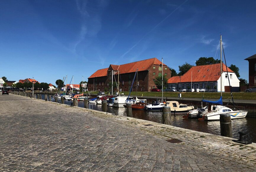 Tönninger Hafen mit vielen verschiedenen Booten und im Hintergrund das große, imposante Packhaus