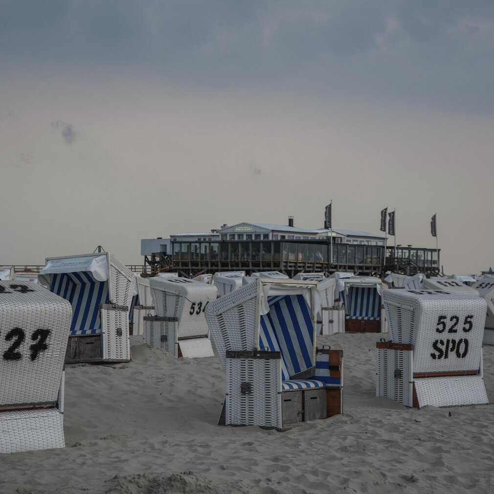 Strandkörbe und das Pfahlbau-Restaurant Arche Noah bei Abenddämmerung