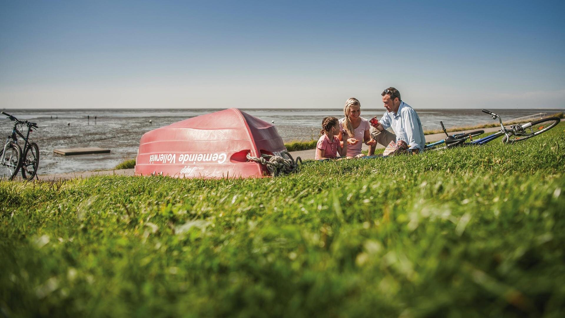 Familie nach einer Radtour am Deich der Badestelle Vollerwiek