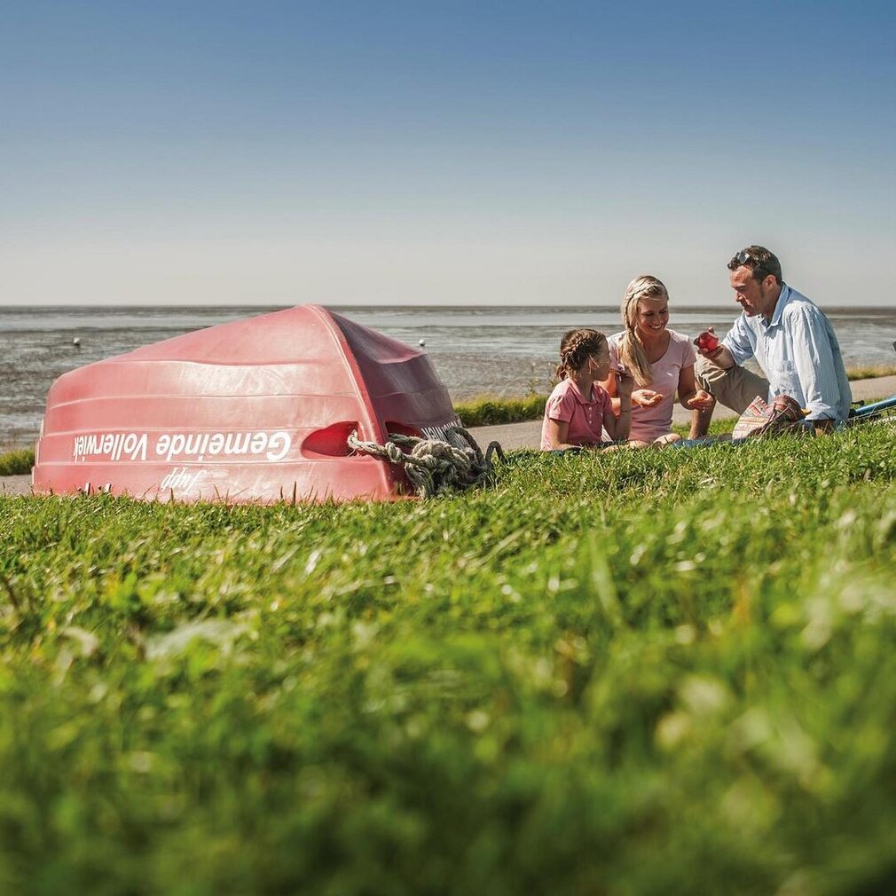 Familie an dem Deich der Badestelle in Vollerwiek