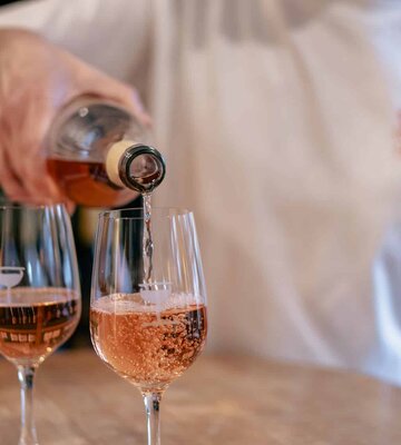 Ein Glas Wein wird eingeschenkt