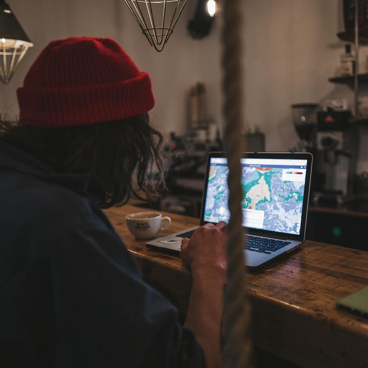 Surferboy am Laptop im Café