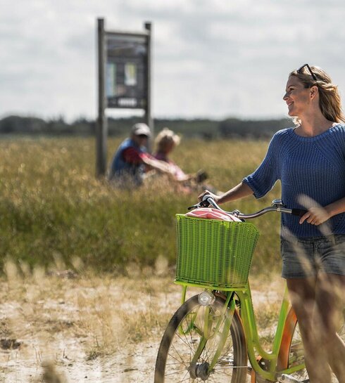 Frau mit grünem Fahrrad im Frühling