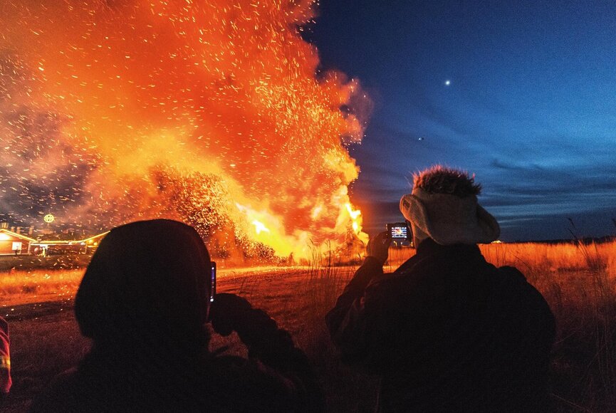 Person fotografiert das Biikefeuer