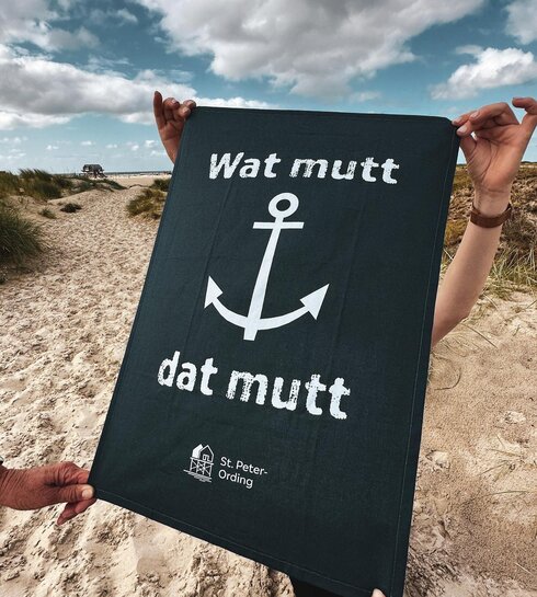 Geschirrhandtuch mit Pfahlbau Aufdruck und dem Spruch "Wat mutt dat mutt"