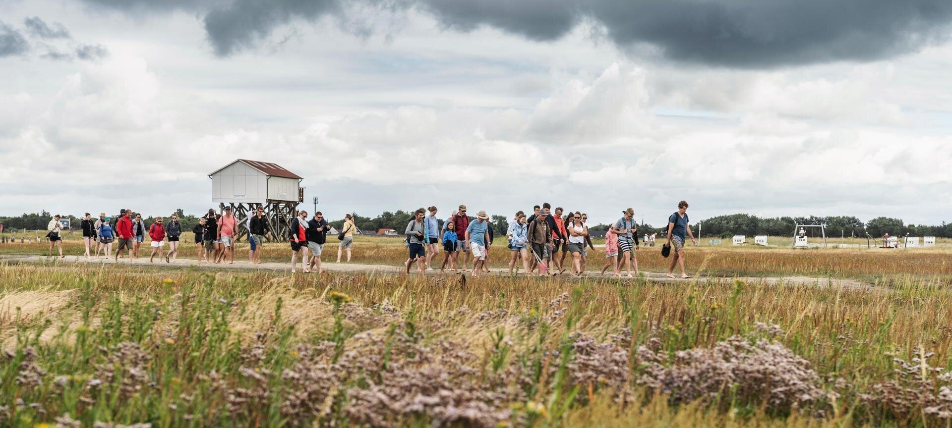 Wattwanderer vor der Kulisse des Südstrandes