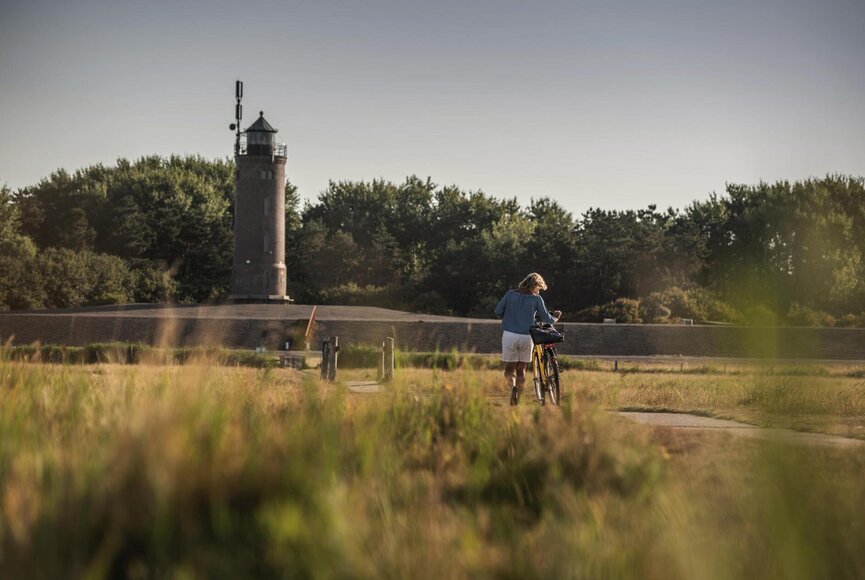 Mann mit Fahrrad vor dem Westerhever Leuchtturm