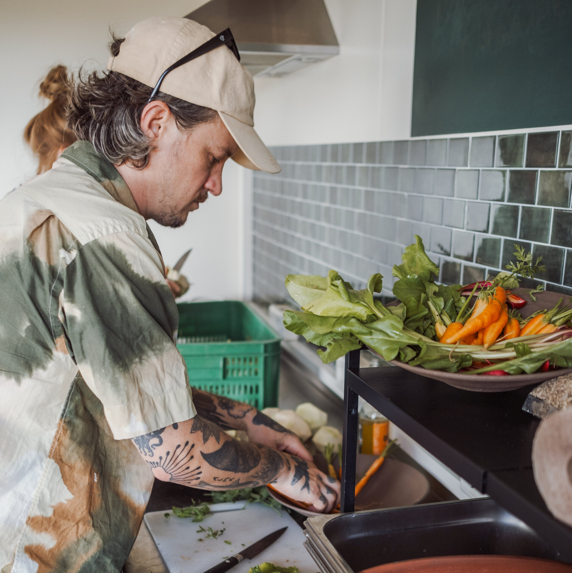 Jo is standing in the kitchen, cutting vegetables