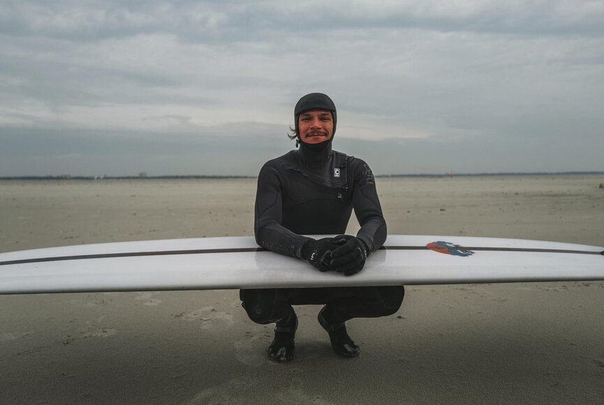 Surferboy mit Surfbrett am Strand