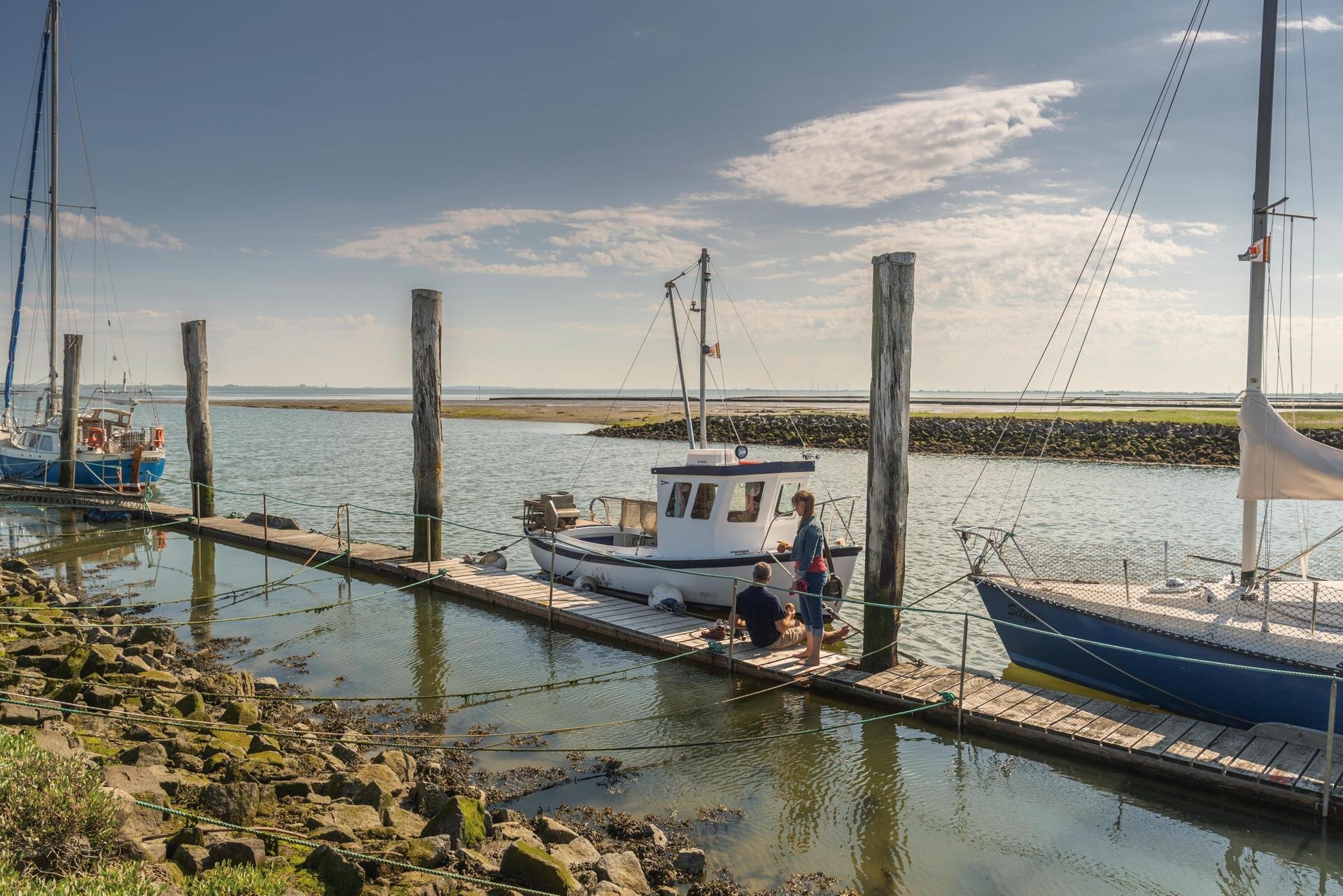 Paar am Steg vom Hafen Tetenbüllspieker mit Booten