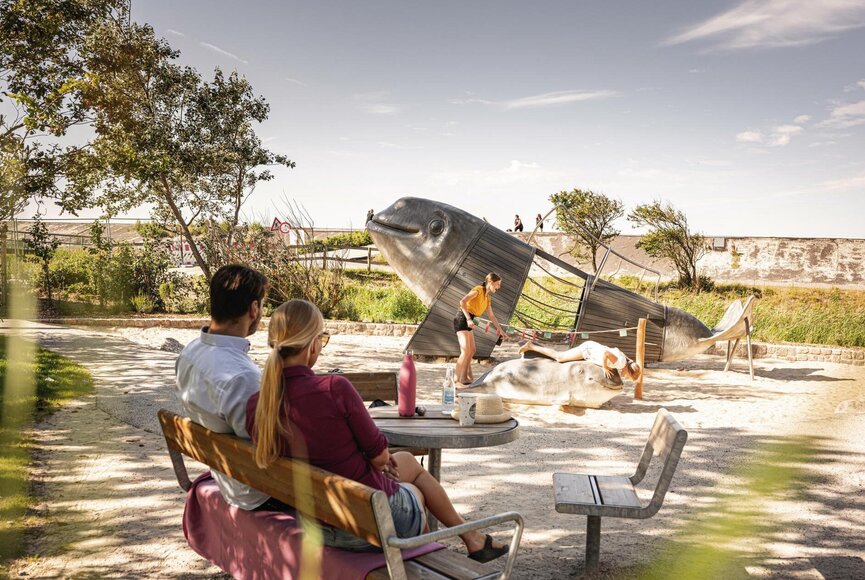Familie beim Schweinswal-Klettergerüst mit Sitzgelegenheiten