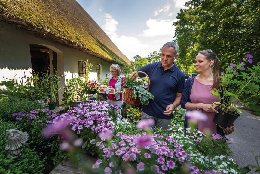 Ein Mann und eine Frau kaufen bunte Frühlingsblumen in einem kleinen Eiderstedter Laden ein.