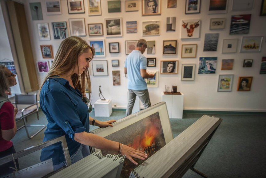Frau schaut Bilder in einer Galerie an