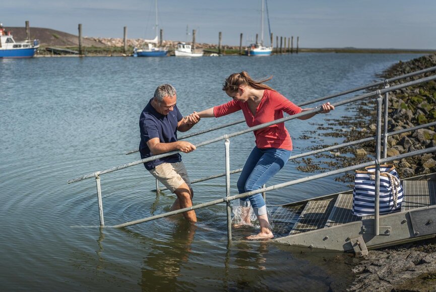 Paar hält sich auf der Treppe an der Badestelle Evershopsiel gegenseitig fest