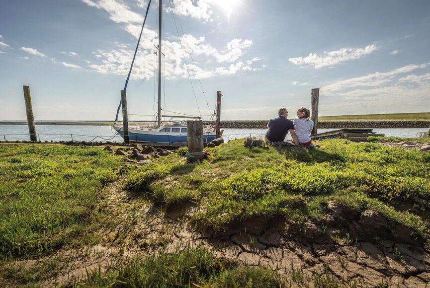 Paar am Hafen in Evershopsiel blickt auf ein Boot