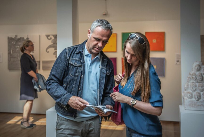 Paar in einer Galerie mit Blick in eine Broschüre