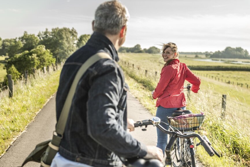 Mann und Frau gucken sich auf Fahrrädern an