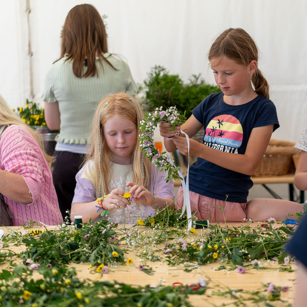 Kinder basteln sich eigene Blumenkränze