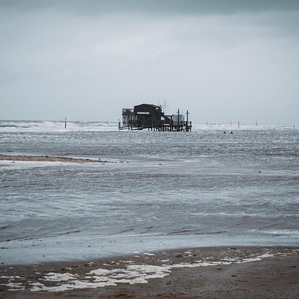 Pfahlbau bei Sturmflut vom Wasser umgeben