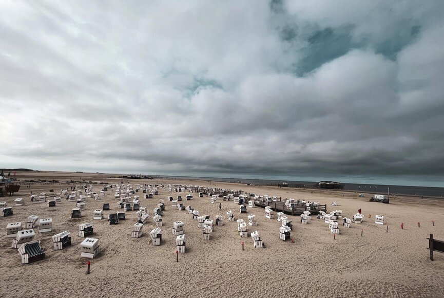 Draufsicht auf den Strand und die Wasserkante mit vielen Strandkörben