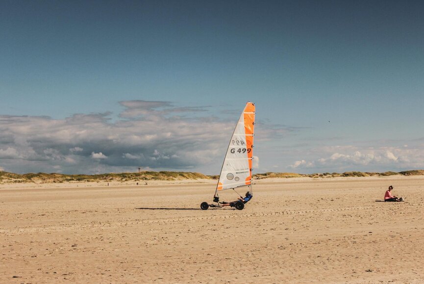 Ein Strandsegler fährt am Strand entlang 