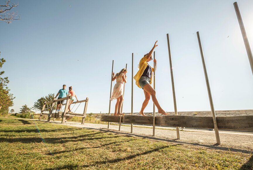 Familie auf Spielgeräten der Erlebnispromenade